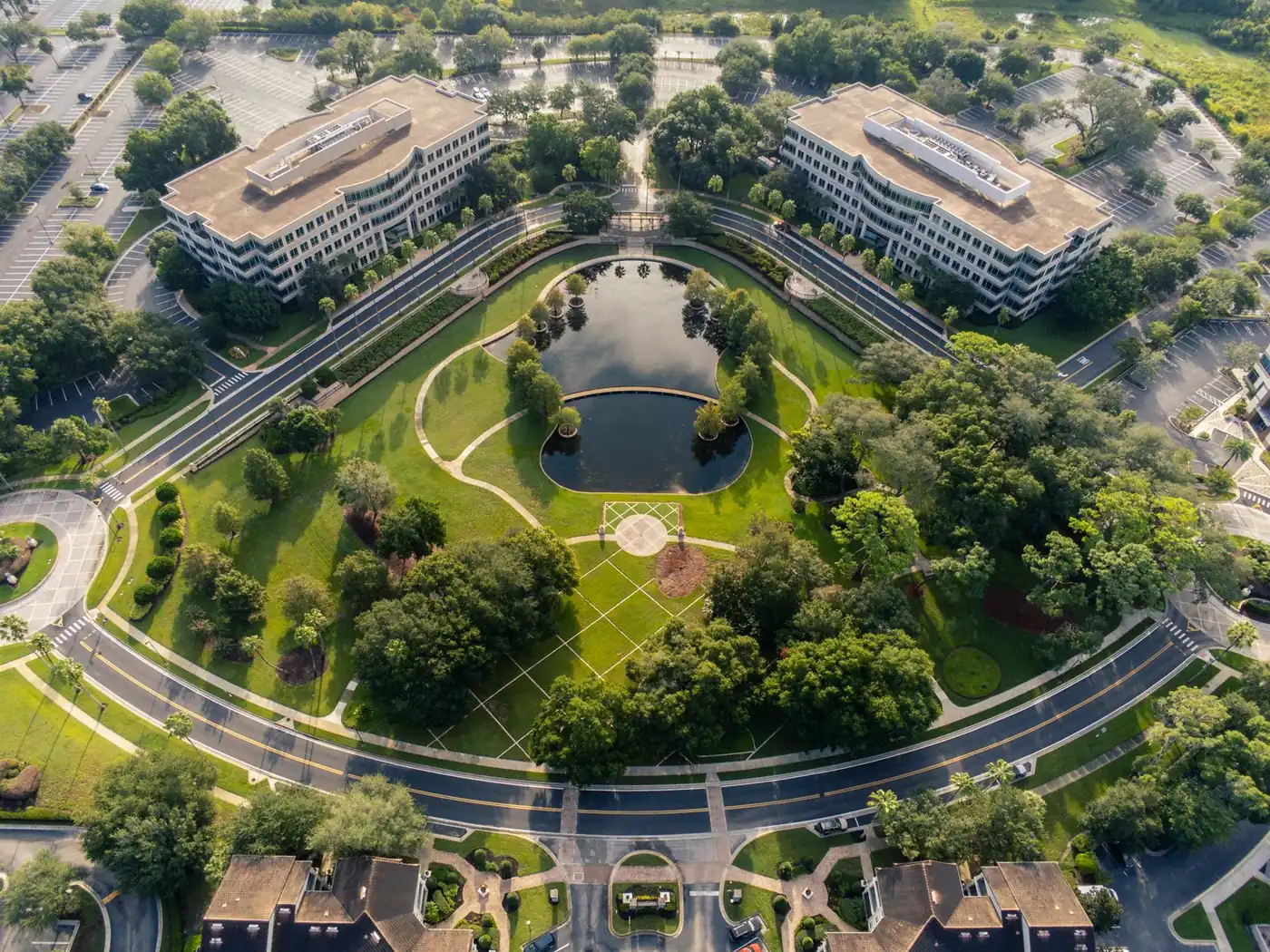Aerial view of low-rise office buildings with flat roofs around retention ponds in a green Gulf Coast office park